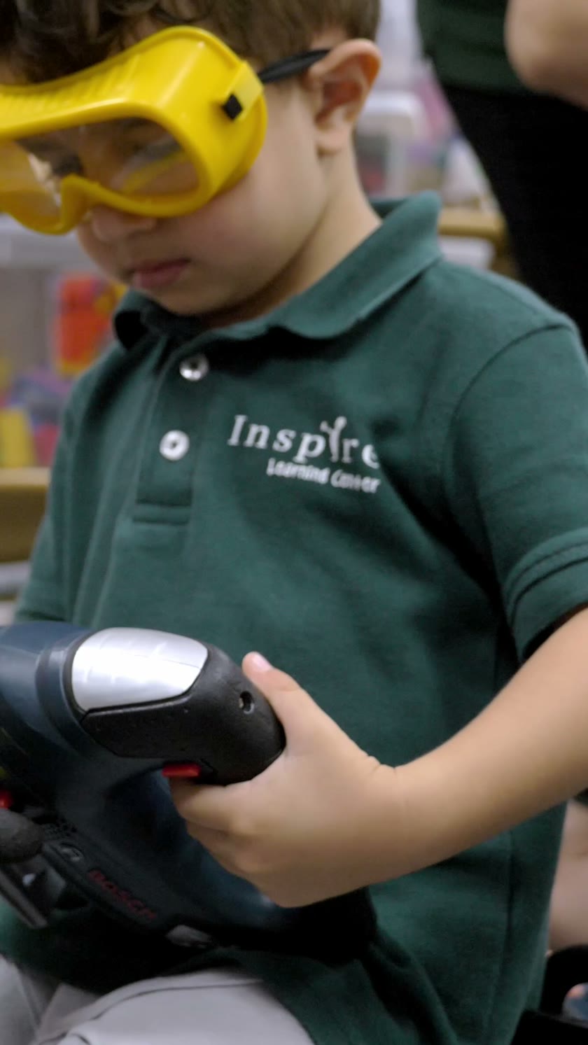 A child wearing yellow goggles during a hands-on classroom activity