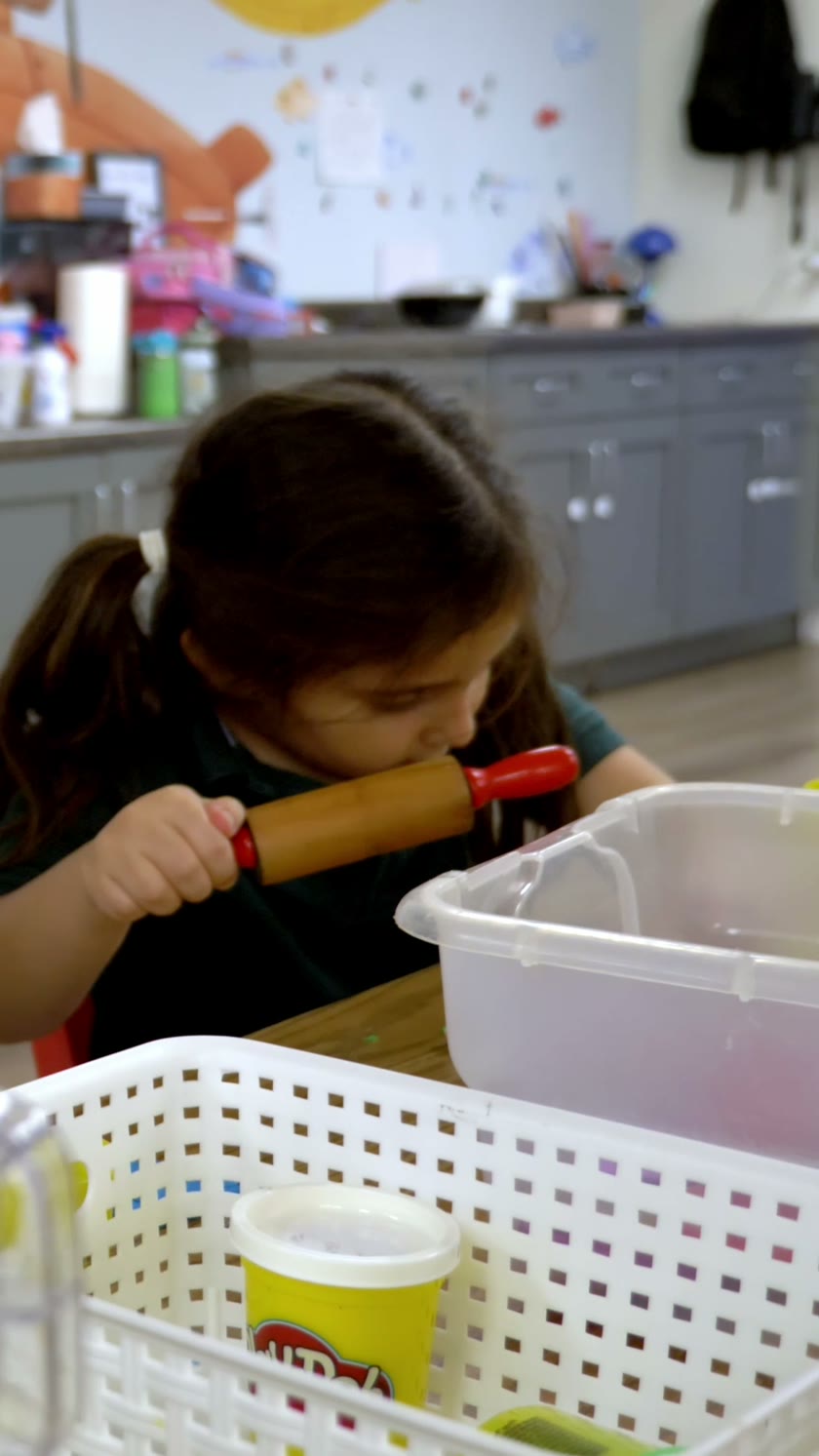 A child exploring materials at an Inspire activity table